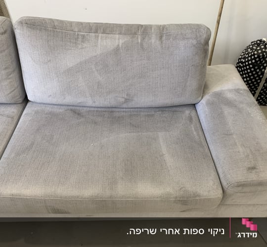 ספה אפורה עם כתמים ולכלוך גלוי